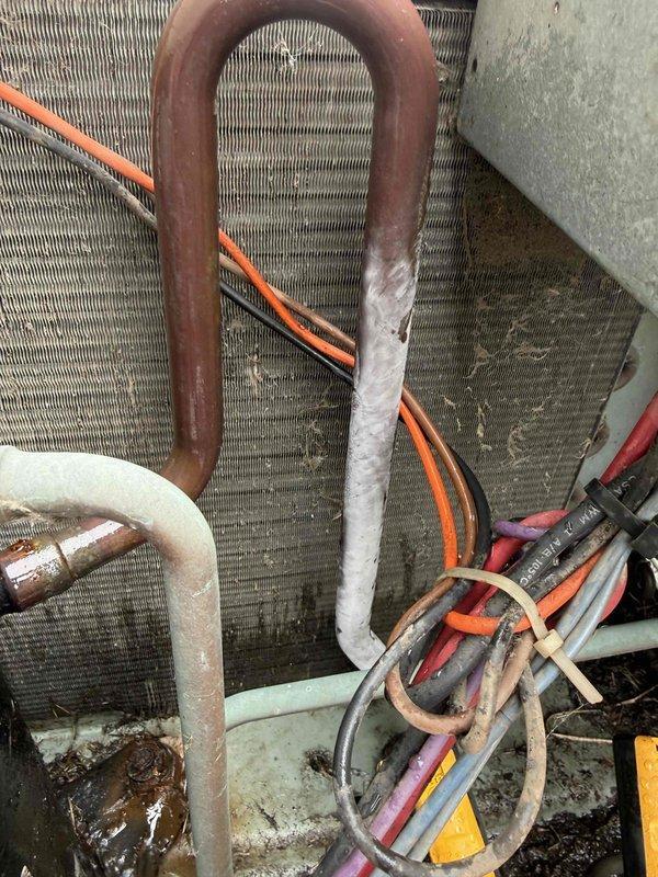 Completed Comfort Plan clean and check maintenance on residential air conditioning system at 1004 Rose Ave. Performed electrical diagnostics using digital multimeter, measuring capacitor and relay components with readings of 33.1 recorded. Inspected condensing unit coil assembly, noting accumulated dirt and debris between aluminum fins requiring attention. Evaluated refrigerant line set condition, observing oxidation on copper piping and checking insulation integrity on suction line. All electrical connections tested and verified operational. System components assessed for proper function per maintenance protocol.