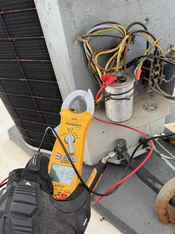 Completed spring preventive maintenance on commercial rooftop HVAC unit. Performed comprehensive system inspection including electrical diagnostics with amp draw readings showing 44.8 amps on compressor circuit. Replaced failed dual run capacitor with new Titan Pro unit and verified proper electrical connections. Inspected condenser coil, verified all wire terminations secure, and documented updated equipment specifications and filter information for maintenance records per contract requirements.