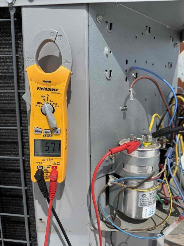 Completed spring preventive maintenance on commercial rooftop HVAC unit per contract specifications. Performed comprehensive system inspection including electrical testing with clamp meter showing 57.1 amp compressor draw, verified capacitor operation and connections, inspected condenser coil condition, and documented equipment specifications and filter information. Updated maintenance checklist and photographed unit components for service records.