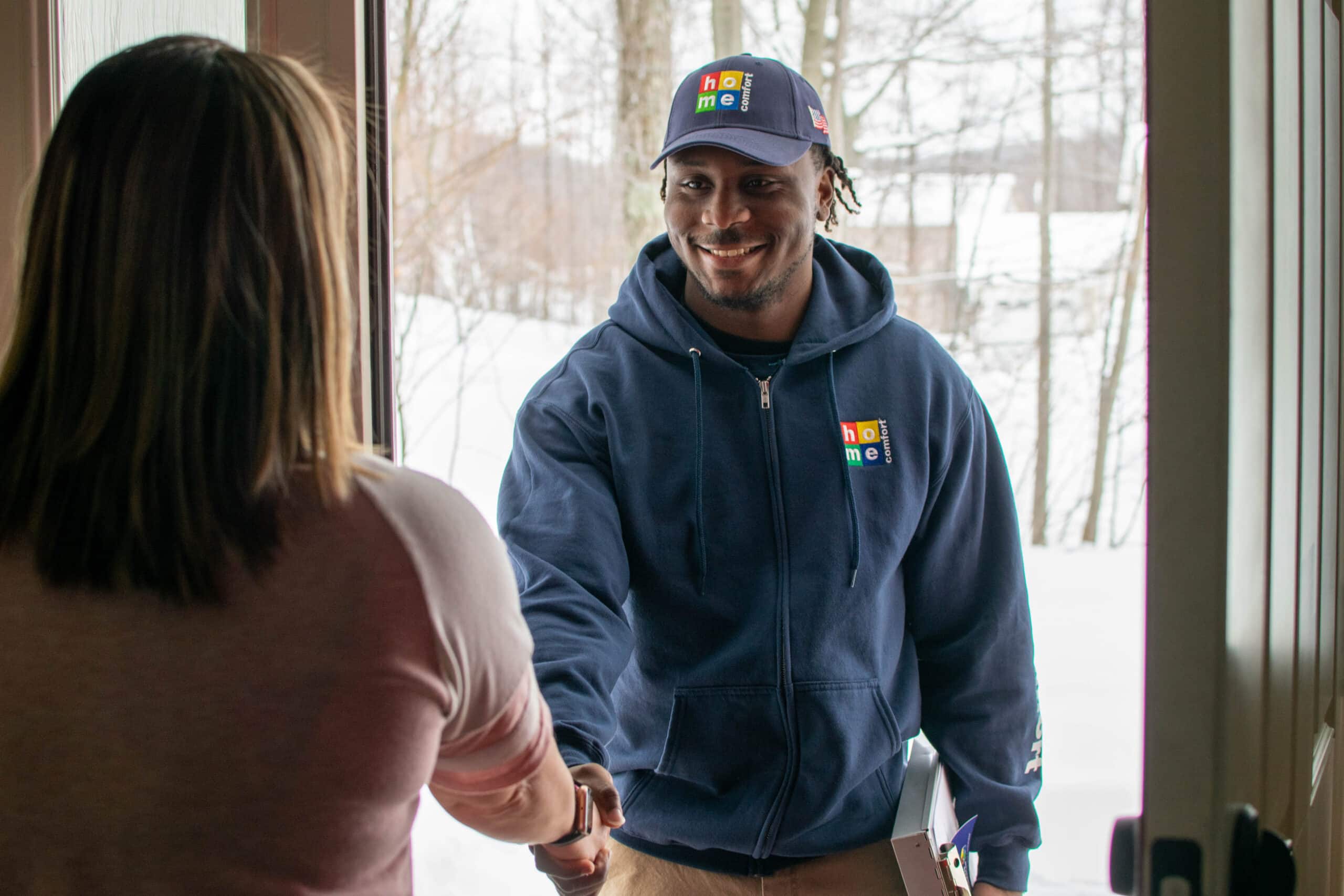 Home Comfort technician shaking the hand of a homeowner during a service call