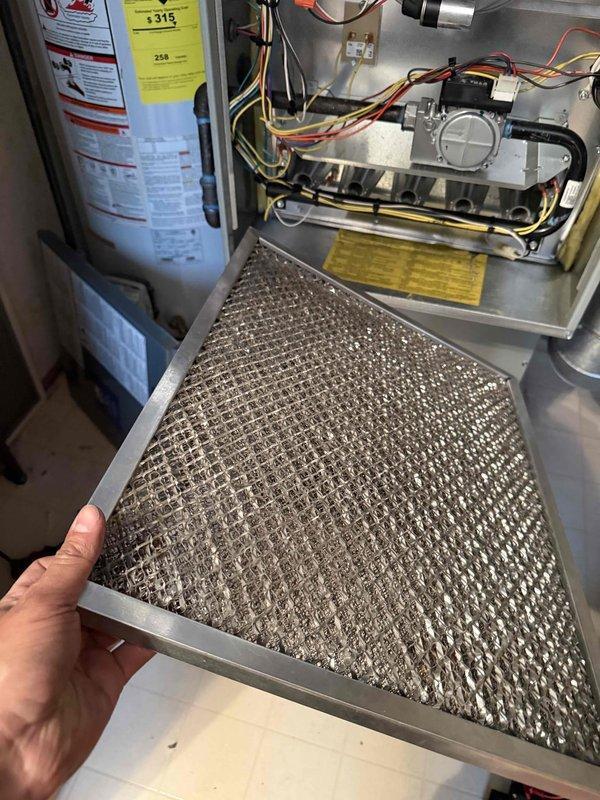 Completed comprehensive tune-up service on residential HVAC system. Performed electrical diagnostics using clamp meter, verified voltage readings at 422V, and inspected capacitor connections and wiring integrity at outdoor condensing unit. Removed and inspected heavily soiled return air filter showing significant dust accumulation, affecting system airflow. Evaluated indoor furnace components including burner assembly and gas valve connections. System operational following service; customer educated on proper filter maintenance schedule to maintain optimal performance and efficiency.