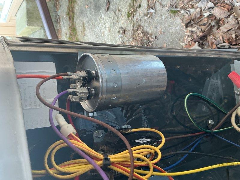 Replaced defective 45/5 MFD dual-run capacitor under warranty on outdoor HVAC unit. Disconnected all electrical connections from failed capacitor, removed old component, installed new capacitor with proper wire terminations to compressor and condenser fan motor circuits, and verified secure mounting and electrical connections before restoring system operation.