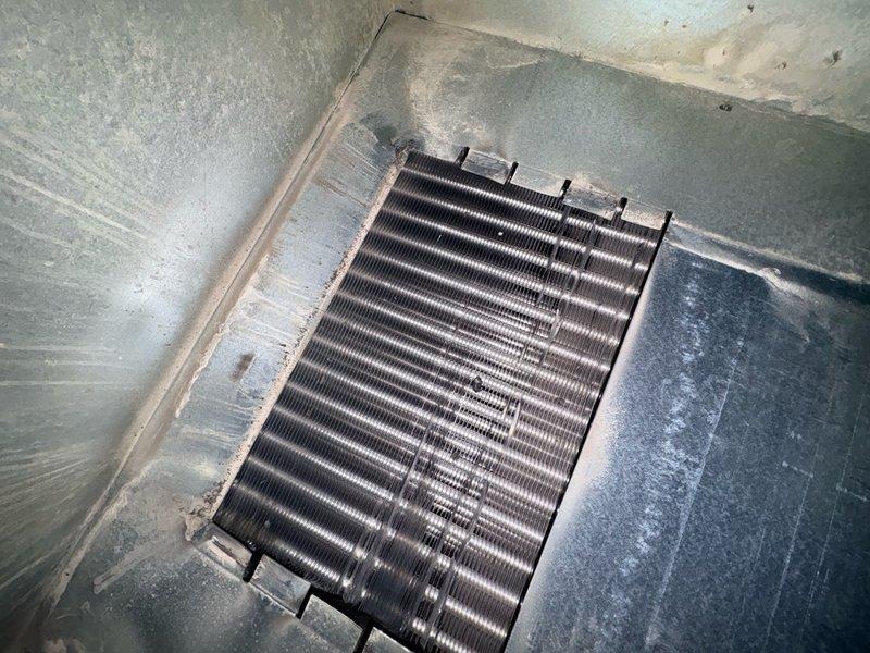 Responded to callback for no heat and burnt smell complaint following recent blower motor replacement on 9-year-old HVAC system. Upon arrival, inspected blower motor assembly and verified proper installation, mounting, and electrical connections. All wire terminations secure with appropriate color-coded wiring including ground wire properly routed. Blower motor operational within housing with no signs of overheating or electrical failure. Inspected evaporator coil and heat exchanger, noting moderate dust accumulation and surface contamination on fins. System tested and confirmed heating operation restored with no abnormal odors detected during runtime.