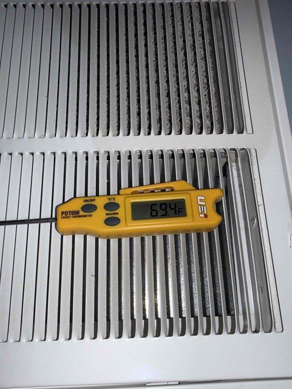 Completed preventative maintenance clean and check on air conditioning and air handler system per service comfort plan. Inspected and verified blower motor operation, confirmed proper mounting and vibration dampening, and documented equipment specifications including Nidec motor assembly. Measured and recorded system temperatures at return air grille, with readings indicating 69.4°F, confirming proper airflow and system performance within normal operating parameters.