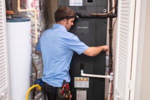 Home Comfort technician installing a heat pump front pane