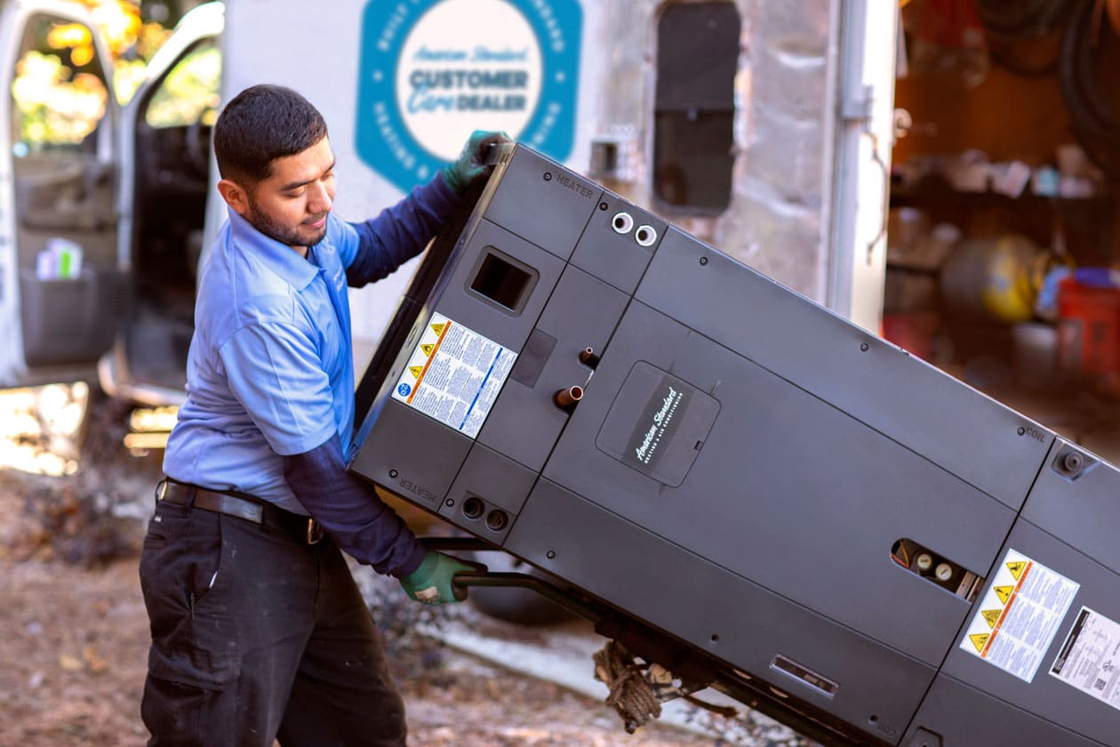 Technician carrying a heat pump unit