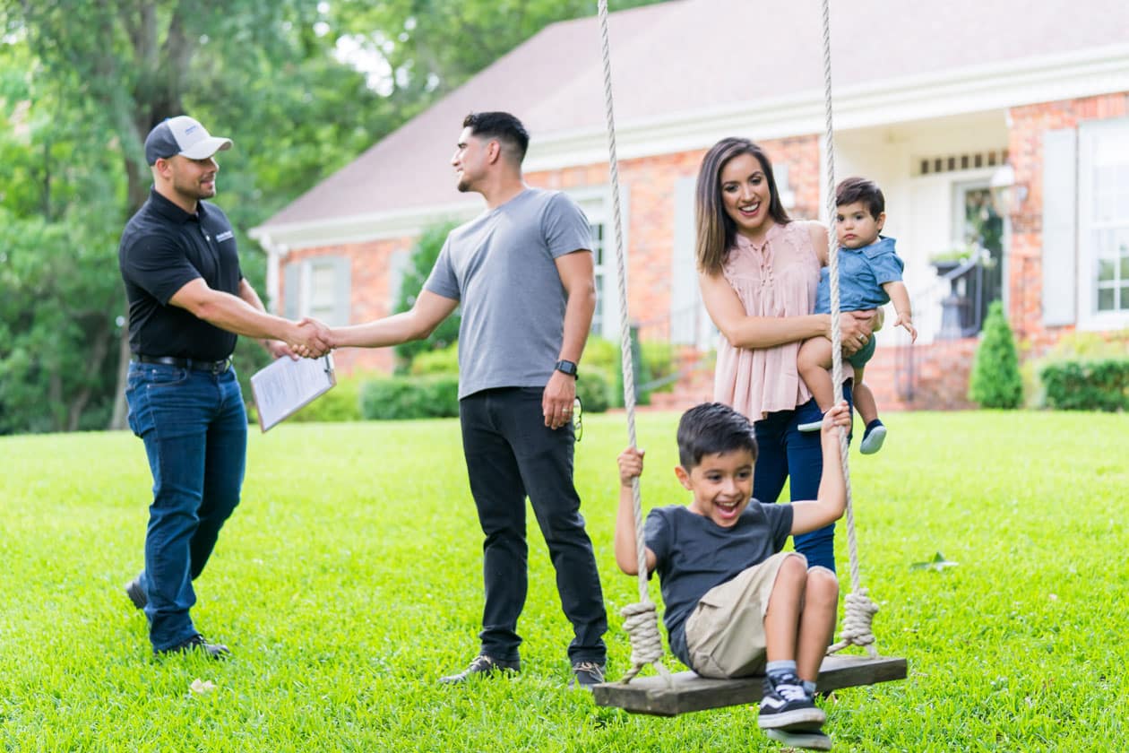 Home Comfort technician shaking hands with a client with his family