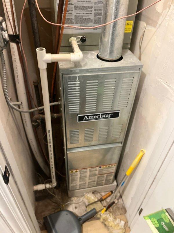 Conducted comprehensive AC replacement estimate for residential system that ceased operation during previous cooling season. Evaluated existing Ameristar furnace/air handler installation with associated refrigerant lines, ductwork, and condensate drainage system in basement utility area. Customer elected to defer repairs at end of last season and is now pursuing complete system replacement options. Documented current equipment configuration including copper refrigerant piping, PVC condensate lines with emergency float switch, electrical conduit, and silver galvanized supply ductwork for accurate replacement specifications.